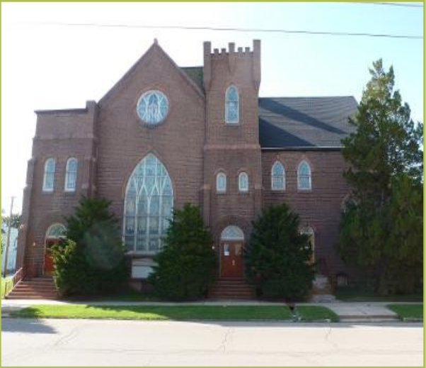 Faith Center Freeport, seen from the Pleasant Street side. The church is built in red brick, and we see the large stained glass windows at the back of the sanctuary.
