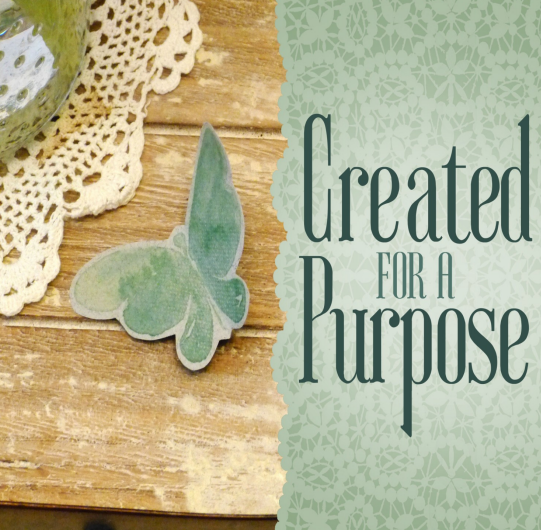 A square graphic divided roughly in half vertically. On the left side, a fine wooden table with a doily on it, and a carefully crafted butterfly painted with green watercolors. On the right side, a mint green background with doily shapes in a slightly lighter green. On it in dark green are the words "Created for a Purpose."